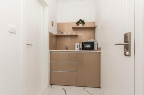 a small kitchen with a microwave and a counter at Villa Božica - sea view stone villa with free parking in Makarska