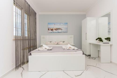 a white room with a bed and a mirror at Villa Božica - sea view stone villa with free parking in Makarska