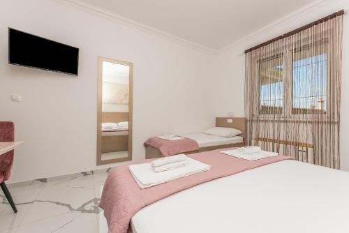 a white room with a bed and a mirror at Villa Božica - sea view stone villa with free parking in Makarska