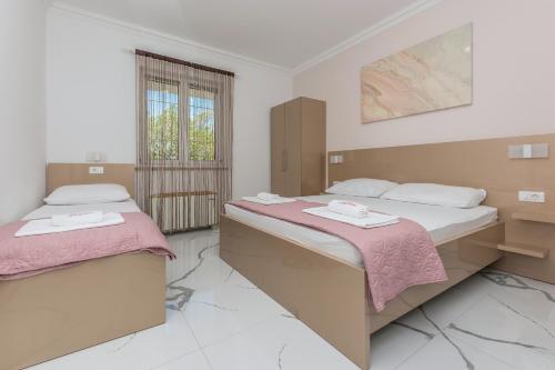 a bedroom with two beds and a window at Villa Božica - sea view stone villa with free parking in Makarska
