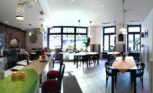 ein Restaurant mit Tischen, Stühlen und Fenstern in der Unterkunft Hotel Klenkes am Bahnhof in Aachen
