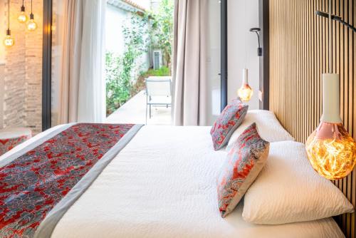 a bedroom with a bed with pillows and a window at Le Confidentiel Hôtel & SPA in Saint-Raphaël