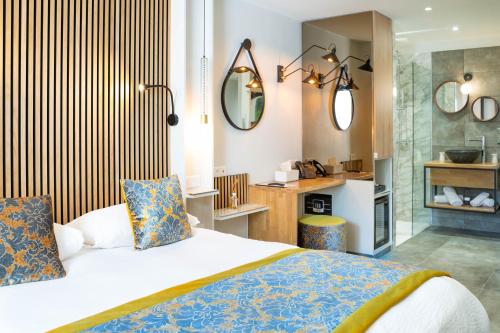 1 Schlafzimmer mit einem Bett und einem Bad in der Unterkunft Le Confidentiel Hôtel & SPA in Saint-Raphaël