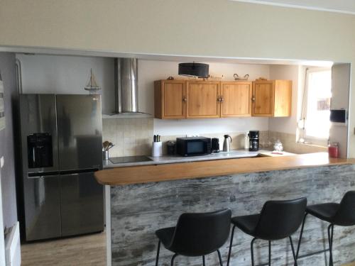 Il comprend une cuisine équipée d'un comptoir avec des chaises et d'un réfrigérateur. dans l'établissement La Petite Allée, à Wimereux