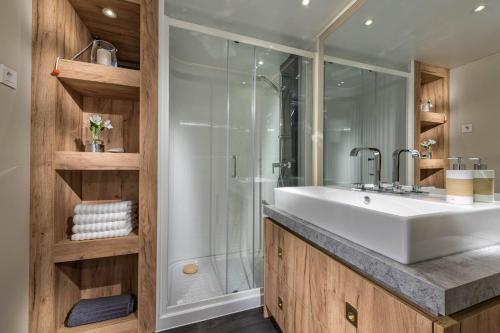 ein Badezimmer mit einem weißen Waschbecken und einer Dusche in der Unterkunft Pálos Resort in Zalacsány