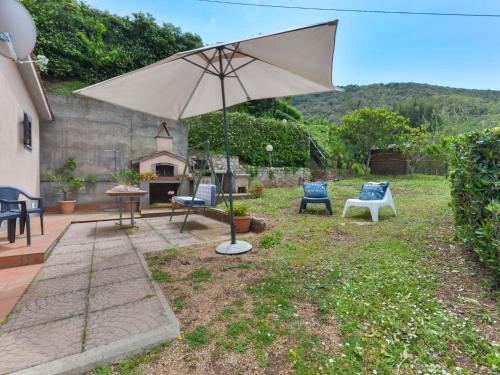 a patio with chairs and an umbrella in a yard at Holiday Home La Paradisa by Interhome in Nisporto