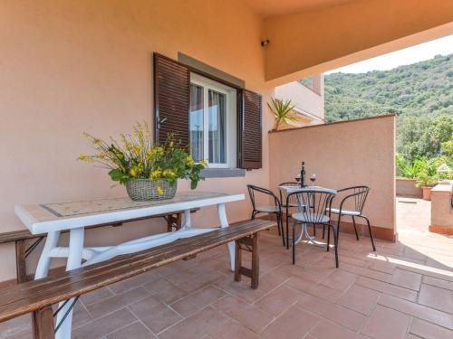 a patio with a bench and a table and chairs at Apartment La Paradisa-3 by Interhome in Nisporto
