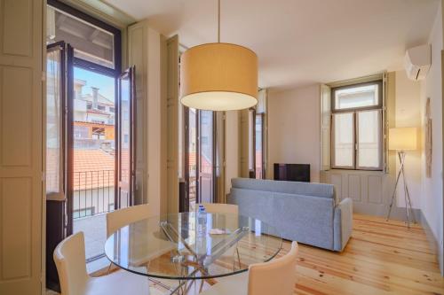 a dining room with a glass table and a couch at Feel Porto Matosinhos Ocean Flats in Matosinhos