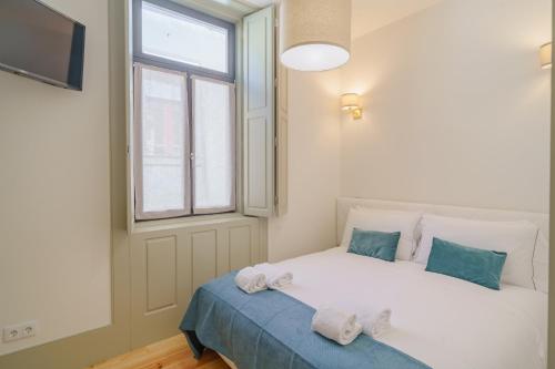 a bedroom with a white bed with towels on it at Feel Porto Matosinhos Ocean Flats in Matosinhos
