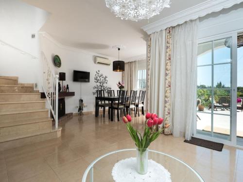 Una sala de estar con un jarrón de flores sobre una mesa. en Holiday Home Villas de Madrid by Interhome, en Estepona