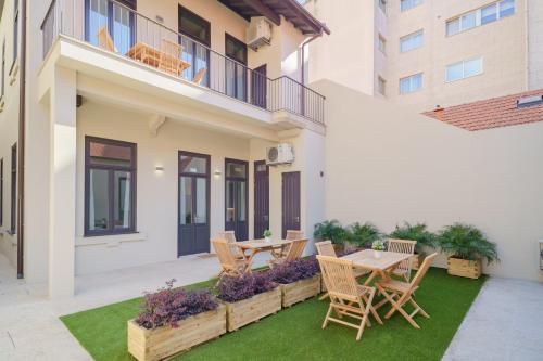 a patio with a table and chairs on a lawn at Feel Porto Matosinhos Ocean Flats in Matosinhos
