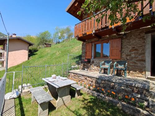 a stone house with a table and chairs in the yard at Holiday Home Casa Crevegno by Interhome in Bubegno