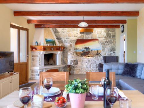 a living room with a table and a stone fireplace at Holiday Home Panorama 1 by Interhome in Labin