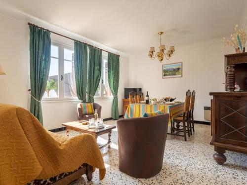 Holiday Home La Vigneronne by Interhome في Fourques: غرفة معيشة مع ستائر خضراء وغرفة طعام
