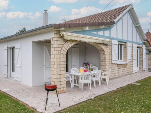 una casa con un patio con mesa y sillas en Holiday Home Villa Hélios by Interhome, en Merville-Franceville-Plage