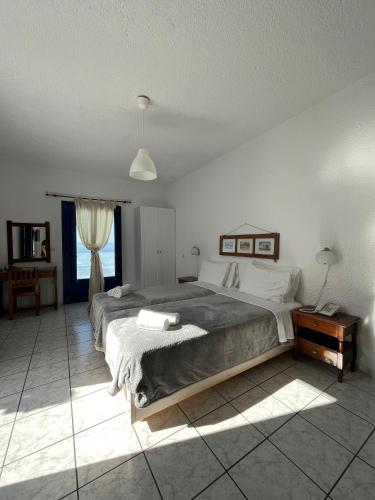 a bedroom with a large bed and a window at Olympic Villas in Oia