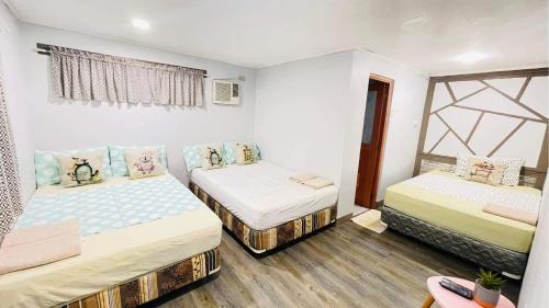 a room with two beds and a window at Calunsag Residence in Siquijor