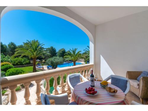 balcón con mesa, sillas y vistas a la piscina en Apartment - SNY160 by Interhome, en Cala Santanyi