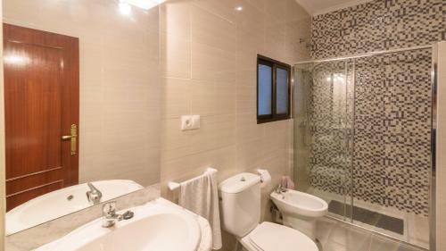 a bathroom with a sink and a toilet and a tub at Complejo Residencial Barquero Pernía Cañete la Real by Ruralidays in Cañete la Real