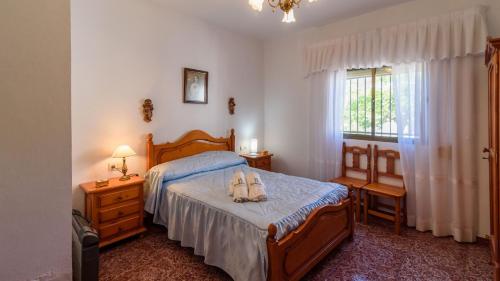 Un dormitorio con una cama con dos zapatos. en Complejo Residencial Barquero Pernía Cañete la Real by Ruralidays, en Cañete la Real