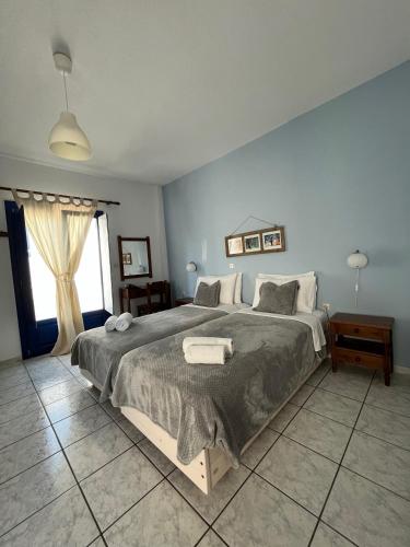 a bedroom with a large bed and a large window at Olympic Villas in Oia