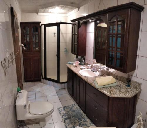 a bathroom with a sink and a toilet and a mirror at Alexander b&b in Alajuela City