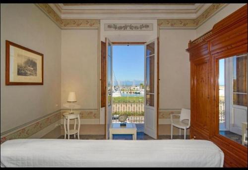 a bedroom with a bed and a large window at Villino Ermione in Marina di Pisa