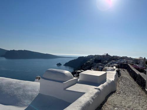 a view of the ocean from the side of a cliff at Olympic Villas in Oia