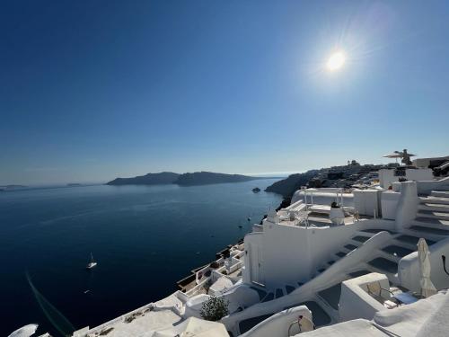 a view of the ocean from a town with white buildings at Olympic Villas in Oia