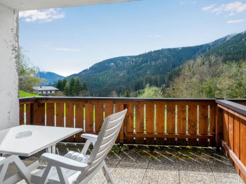 einen Balkon mit einem Tisch, Stühlen und Bergen in der Unterkunft Apartment Holiday-2 by Interhome in Zell am See