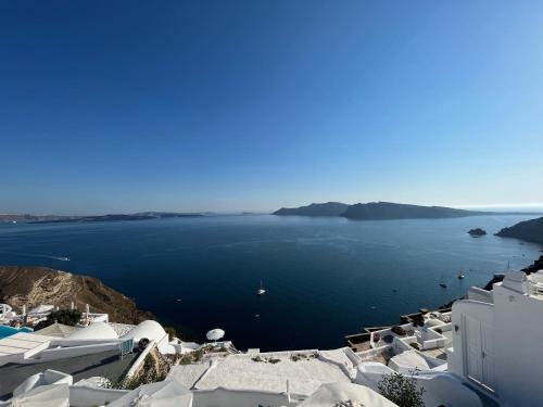 a view of a large body of water with white buildings at Olympic Villas in Oia