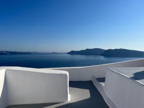 a white balcony with a view of the ocean at Olympic Villas in Oia
