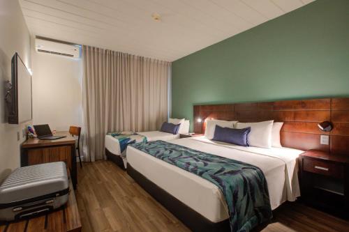 a hotel room with two beds and a chair at Cyan Resort by Atlantica in Itupeva