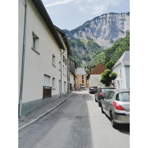 a street in a town with cars parked on the street at L'opale in Le Bourg-dʼOisans