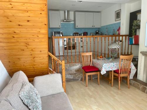 a living room with a table and chairs and a kitchen at Windsor View in Hebden Bridge