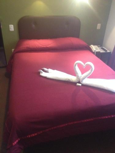 a white heart on a bed with a red blanket at Casa Grande Colonial Palace in Cusco