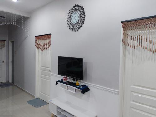sala de estar con TV en una pared blanca en Homestay Qaseh Kerteh, en Kertih