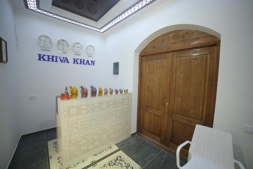 a room with a wooden door and a white chair at Khiva Khan Hotel in Khiva