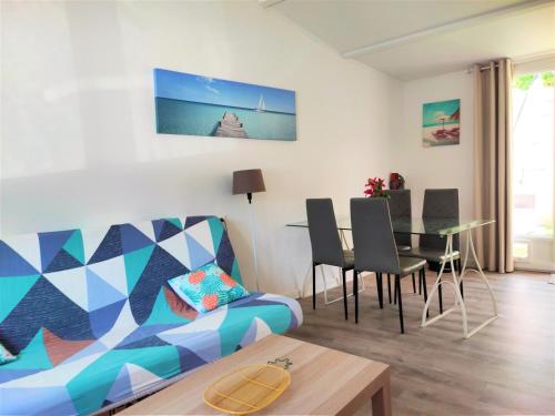 uma sala de estar com um sofá e uma mesa em Maison T2 proche mer jardin spa jacuzzi et parking em Six-Fours-les-Plages