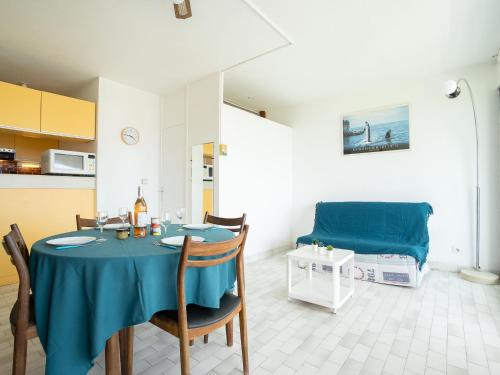 une salle à manger avec une table bleue et un lit dans l'établissement Studio Les Terrasses de la Mer-10 by Interhome, à La Grande Motte