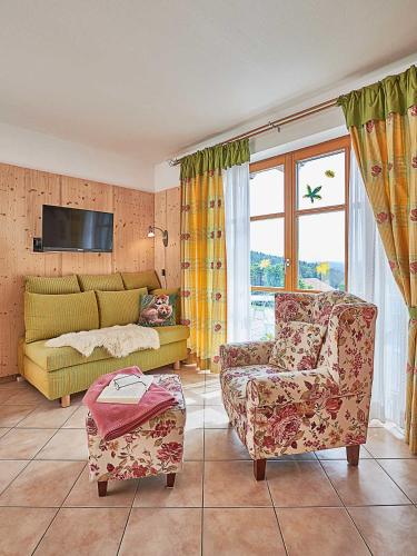 a living room with a couch and a chair at Zum Sonnenhuegel in Wegscheid