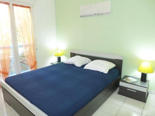 - une chambre avec un lit bleu avec deux oreillers et une fenêtre dans l'établissement Apartment Le Clos Saint Saens-1 by Interhome, à Saint-Aygulf