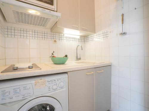 eine Küche mit einer Waschmaschine und einem Waschbecken in der Unterkunft Apartment Les Rives du Lac-7 by Interhome in Le Grau-du-Roi
