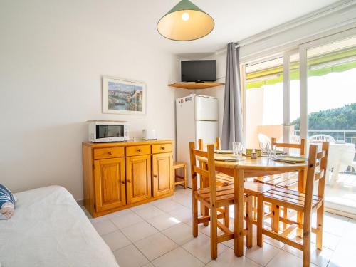 eine Küche und ein Esszimmer mit einem Tisch und Stühlen in der Unterkunft Apartment Les Rives du Lac-7 by Interhome in Le Grau-du-Roi