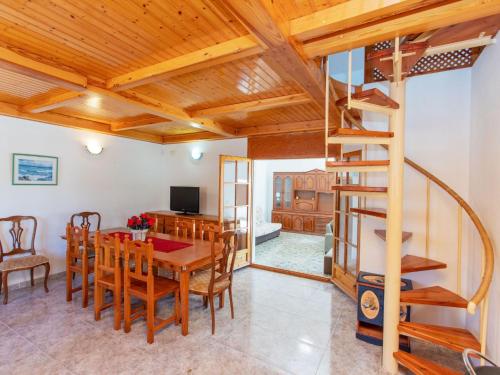 a dining room and living room with a wooden ceiling at Villa Villa Palma by Interhome in Les tres Cales