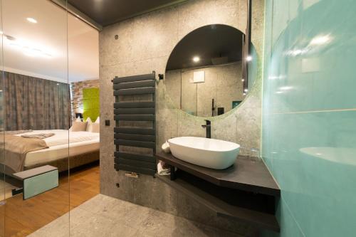 a bathroom with a sink and a mirror and a bed at Landhotel Anna in Sankt Martin am Tennengebirge