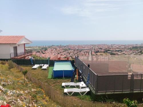 a swimming pool on top of a hill with a house at Casaemy in Pineda de Mar