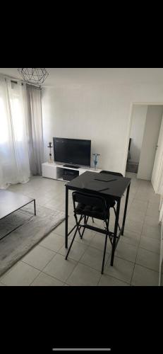 un salon avec une table et une télévision dans l'établissement Magnifique T2 sur Marseille avec parking, à Marseille