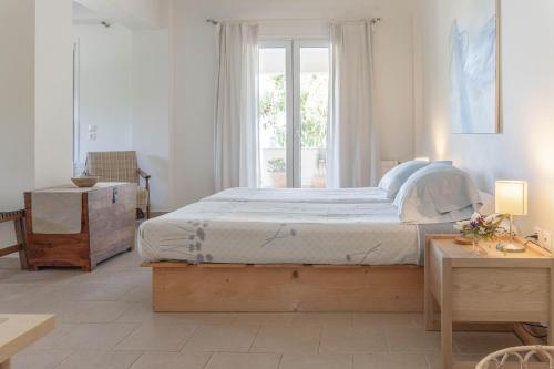a bedroom with a large bed and a window at Secluded Beach Apartments in Skala