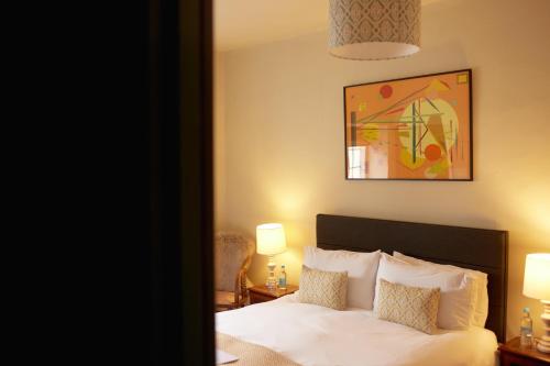 a bedroom with a bed and a painting on the wall at The Grosvenor Arms in Hindon